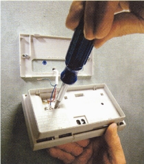 Using lettered tape tags to keep track of new hookups, connect the wires to the terminal screws of the new thermostat, then snap onto mounting plate.