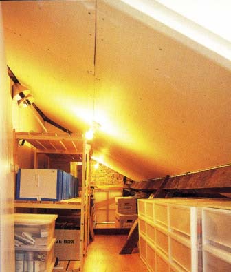 In this narrow hall, shallow open shoe racks, fitted floor to ceiling, take up less space than a conventional closet.